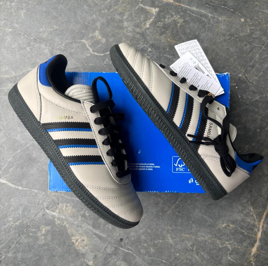 Modelo:JR0965.Zapatillas Adidas Samba color gris con franjas negras y detalle azul en el talón